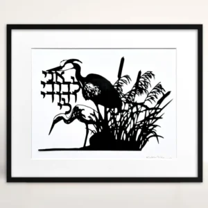 Black papercut artwork depicting two herons in a marsh setting with cattails and reeds. The artwork includes Hebrew text and is set against a white background. The herons are in silhouette.