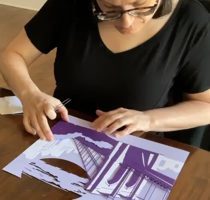 Evelyn works on her Brooklyn Bridge papercut artwork