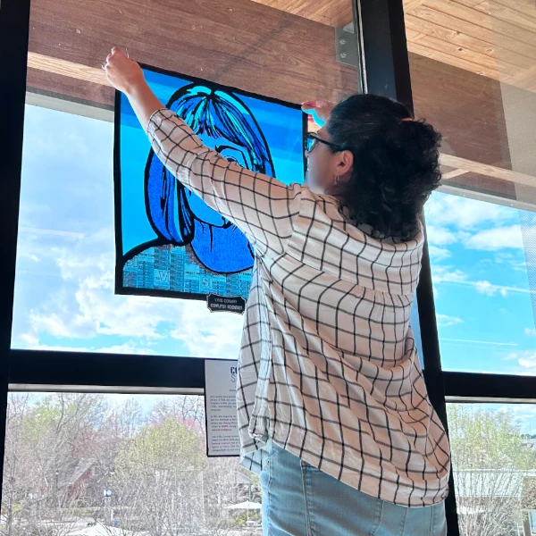 Evelyn hanging up a papercut at her public library
